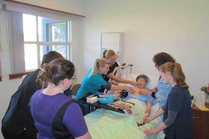 A hands-on assessment of the patient being conducted by students in the Bachelor of Science in Nursing program