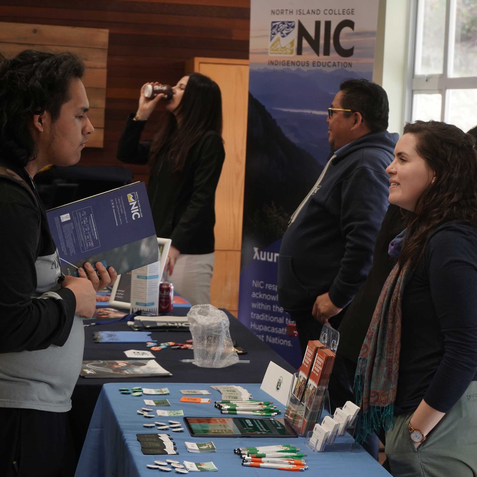 A student asking questions at an information booth at NIC Fest