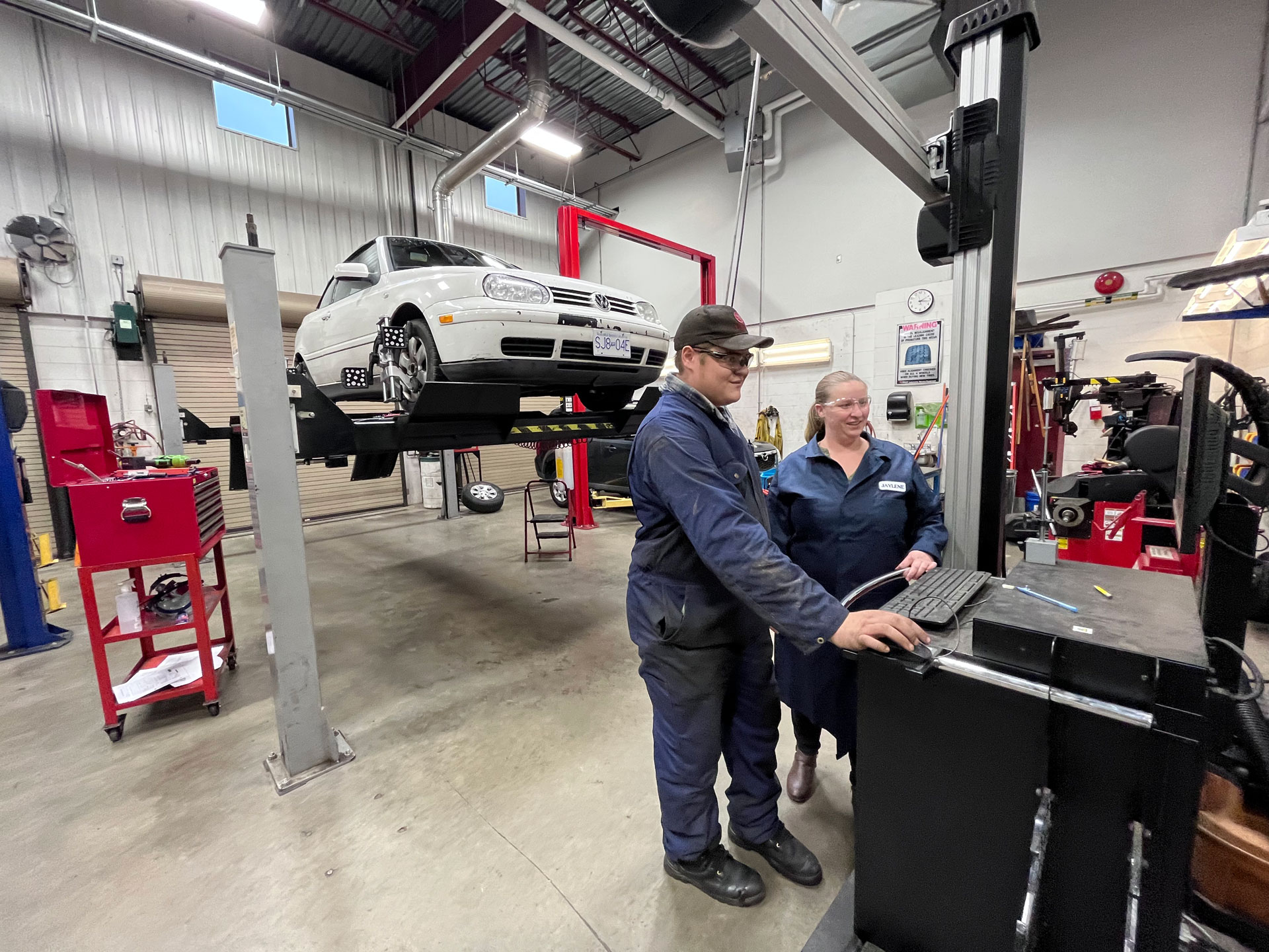 NIC instructor Jaylene Van Der Merwe demonstrates machinery to studen in our Campbell River automotive shop
