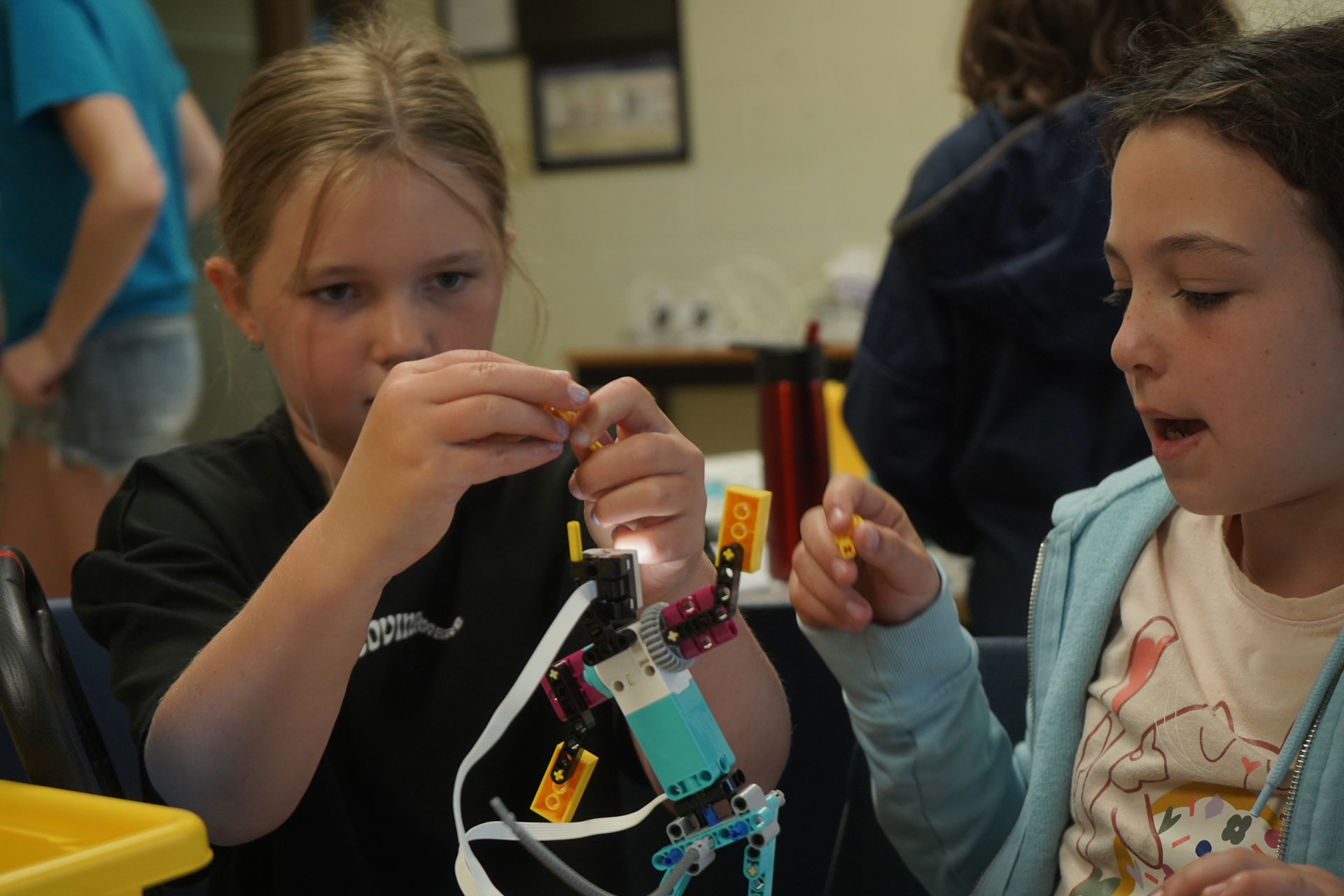 Two Youth Academy Robot Camp participants working on a bot